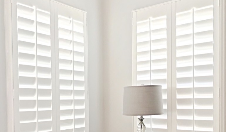 Plantation shutters can be found in a variety of neutral whites and wood stains. Plantation shutters in a corner window.