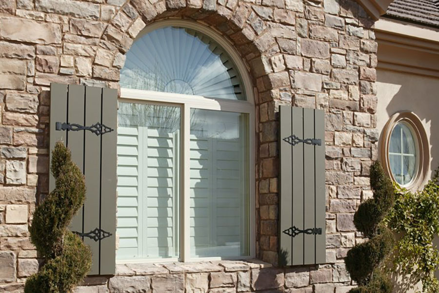  Exterior view of white Polywood shutters on a front window