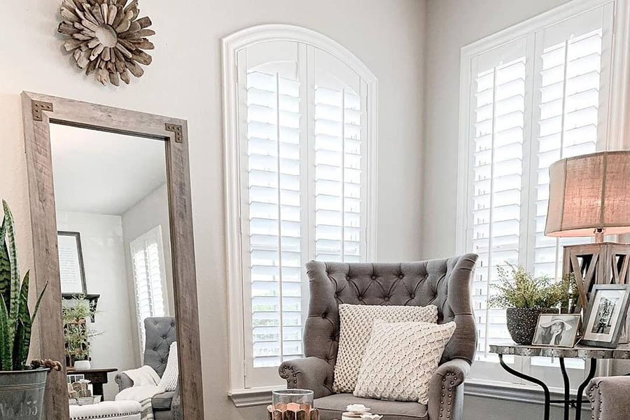 Tall white interior shutters in corner of sitting area