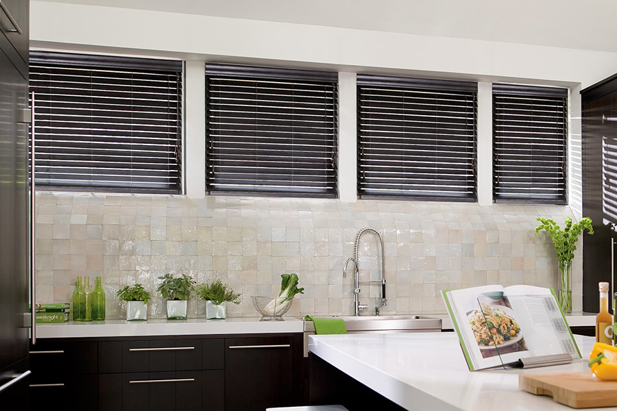Choose custom Polywood faux wood blinds for your kitchen in Fort Lauderdale. Special shaped faux wood blinds in several windows above a sink.