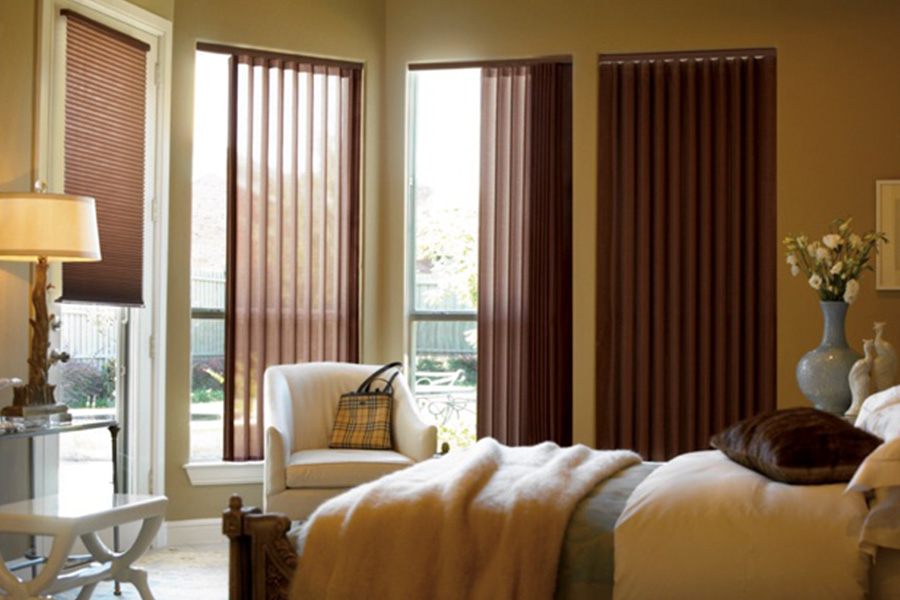 Choose durable and high-quality fabric or vinyl vertical blinds in Fort Lauderdale. Maroon fabric vertical blinds inside a bedroom