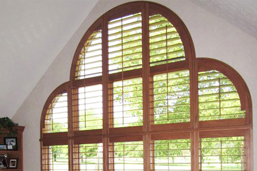 Ovation shutters with a special shaped arched window in a living room.