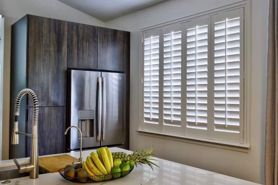 Homeowners use indoor window shutters in Fort Lauderdale when they want attractive and functional window treatments. Polywood shutters on a large kitchen window