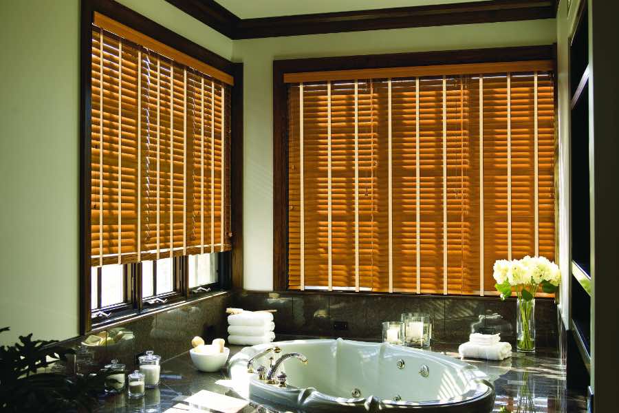 Premium quality blinds are always a stylish accent in your Fort Lauderdale home. Brown wood blinds on large windows in a green bathroom