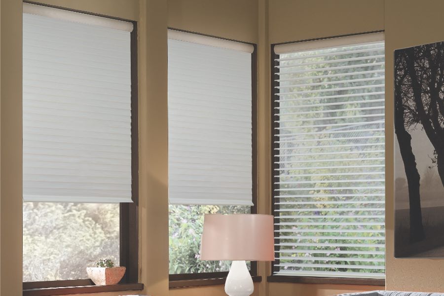 Opaque motorized window shades in Fort Lauderdale keep hot UV rays out of your home. Gray motorized sheer shades on corner windows next to gray furniture