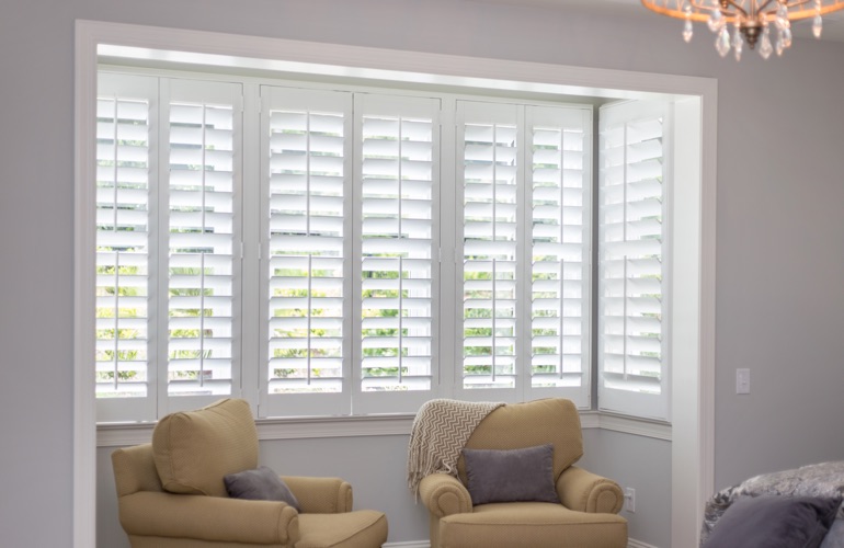 North-South windows have energy efficiency issues instead of sun glare problems. White plantation shutters in sitting area