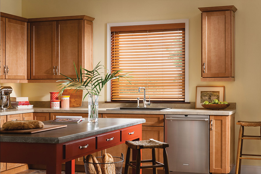 Waterproof faux wood blinds are durable and give you privacy and light control in your Fort Lauderdale kitchen. Dark faux wood blinds above a kitchen sink