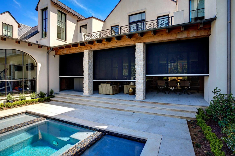 Screen shades on the openings of a home patio leading to a pool
