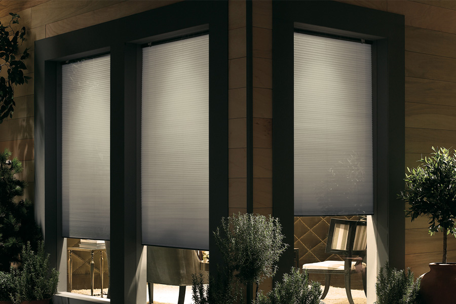 Cellular shades are modern and stylish window treatments for your home in Fort Lauderdale. Dark gray cellular shades displayed from the exterior of a home.